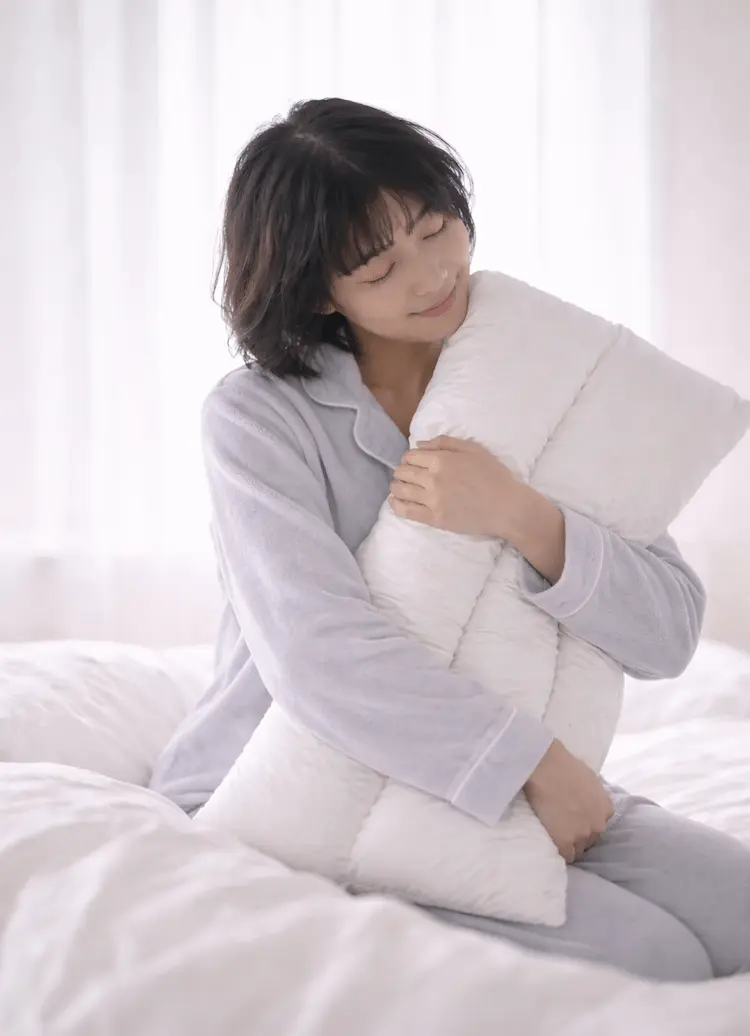 枕を抱える人物イメージ