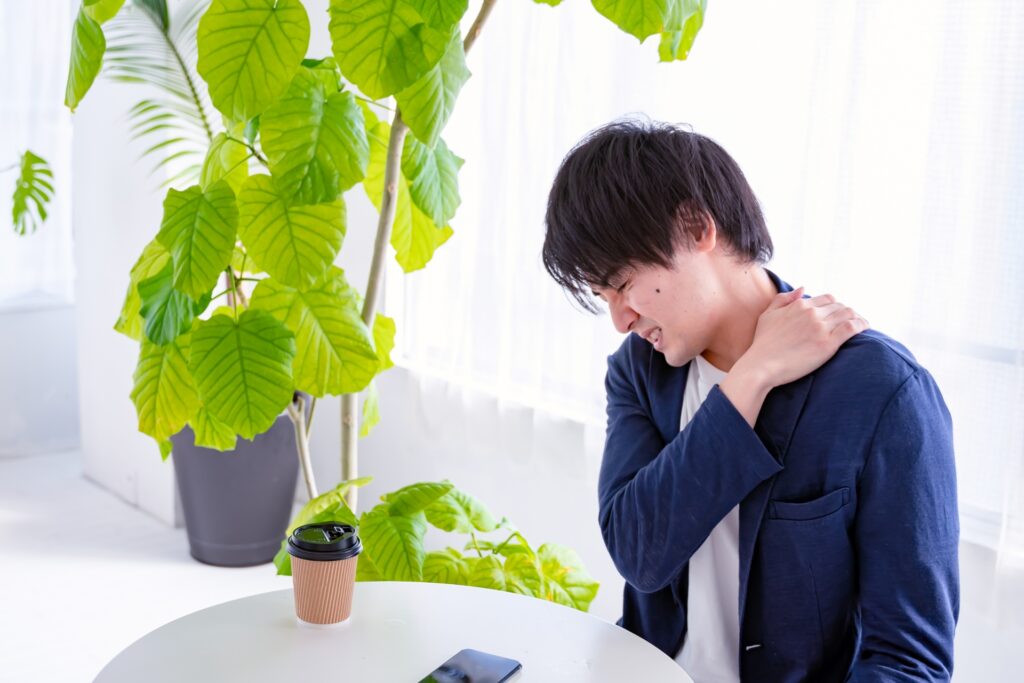 肩、首こりを抱えている男性